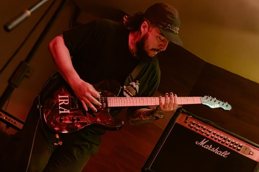 Dres X tocando la guitarra en un concierto de Kraimz