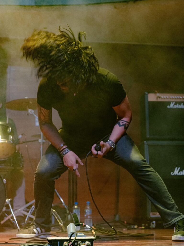 Warren sobre el escenario con el micrófono durante un concierto de Kraimz