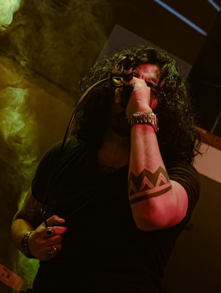 Warren cantando al micrófono durante un concierto de Kraimz
